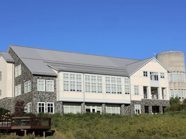 A commercial building with a stone and siding exterior. The combination of modern and rustic architectural styles is highlighted with extensive use of stone and large windows